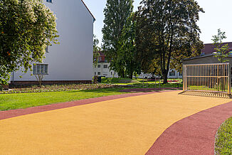 Barrierefreie Spiel- und Bewegungsfläche in Berlin-Steglitz-Zehlendorf mit REGUPOL playfix fun Fallschutzboden und REGUPOL multicourt DLX Spielfeldboden.