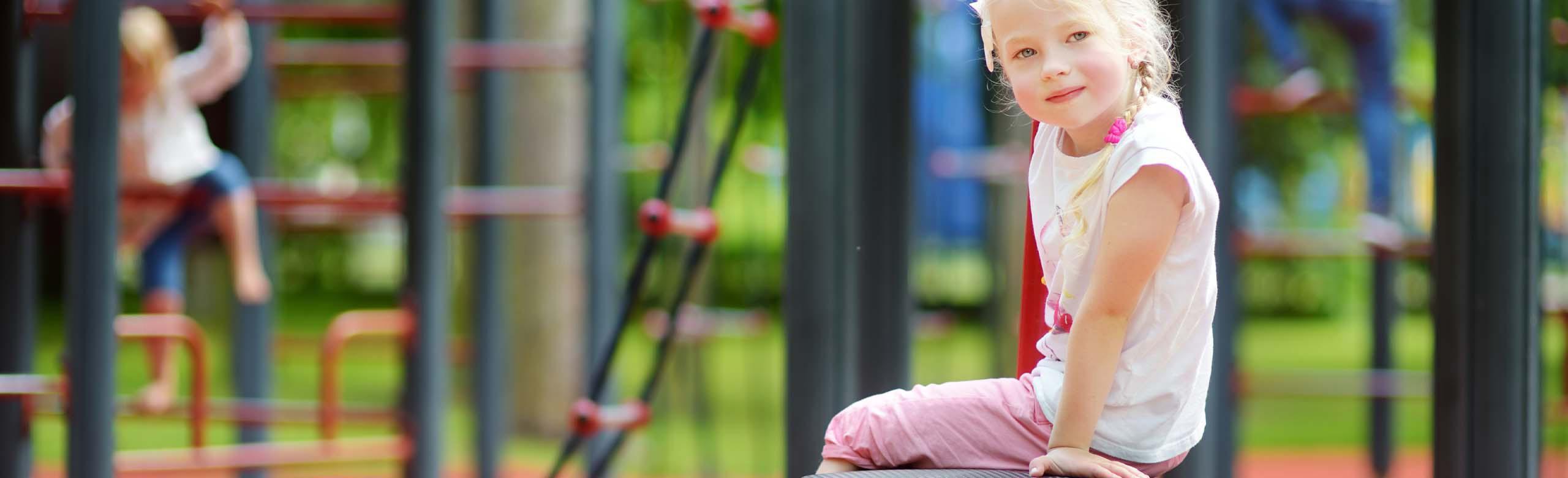 Child playing on a playground with REGUPOL playfix edging installed - the elastic edging for playgrounds